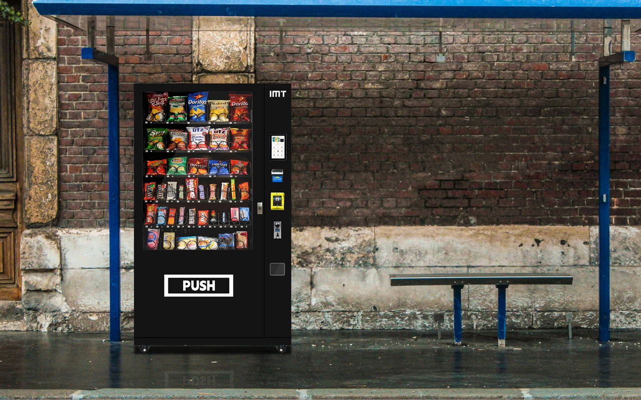 Black snack and drink vending machine at a bus stop.